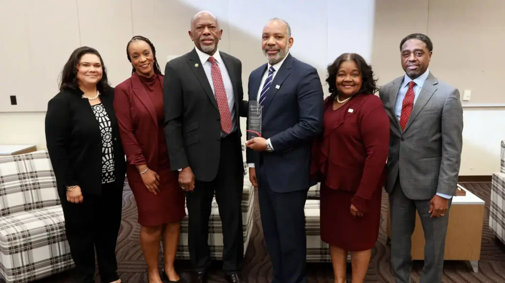 Group smiling while accepting an award.