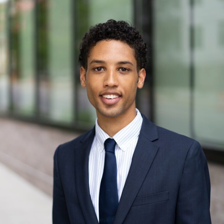 Man in suit standing in front of building.