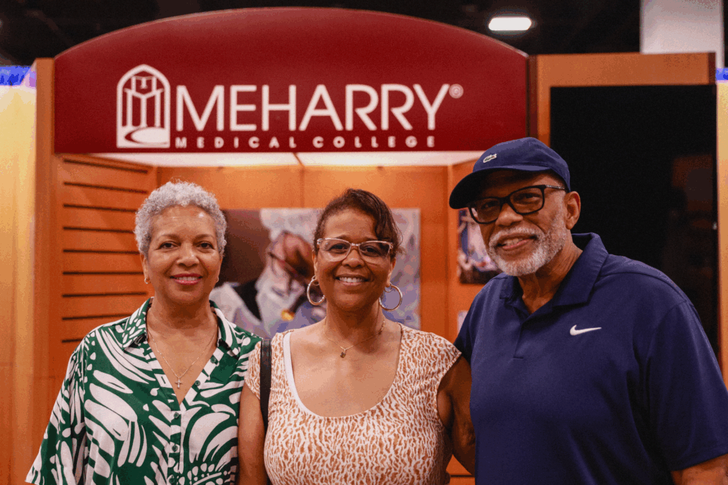 Three people posing in front of a booth.