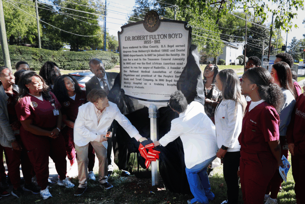 People gathered around a plaque, celebrating a historical event.