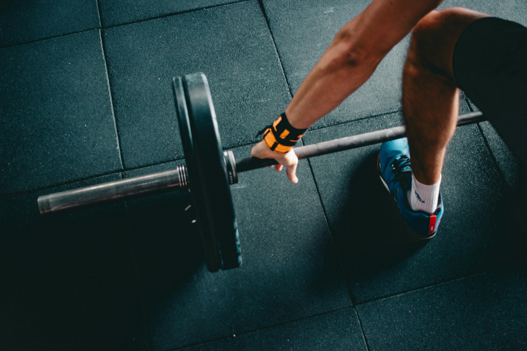 A person lifting a barbell in a gym.