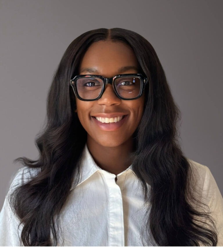 Woman with long hair, glasses, and a smile.
