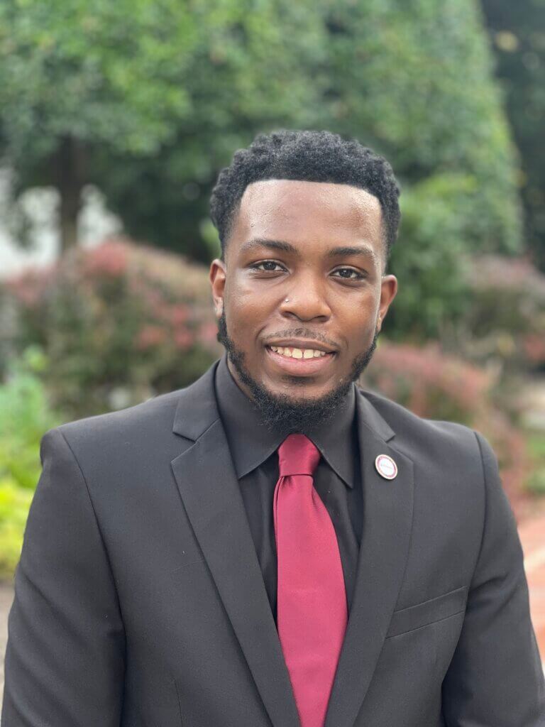 Man in suit standing outdoors.
