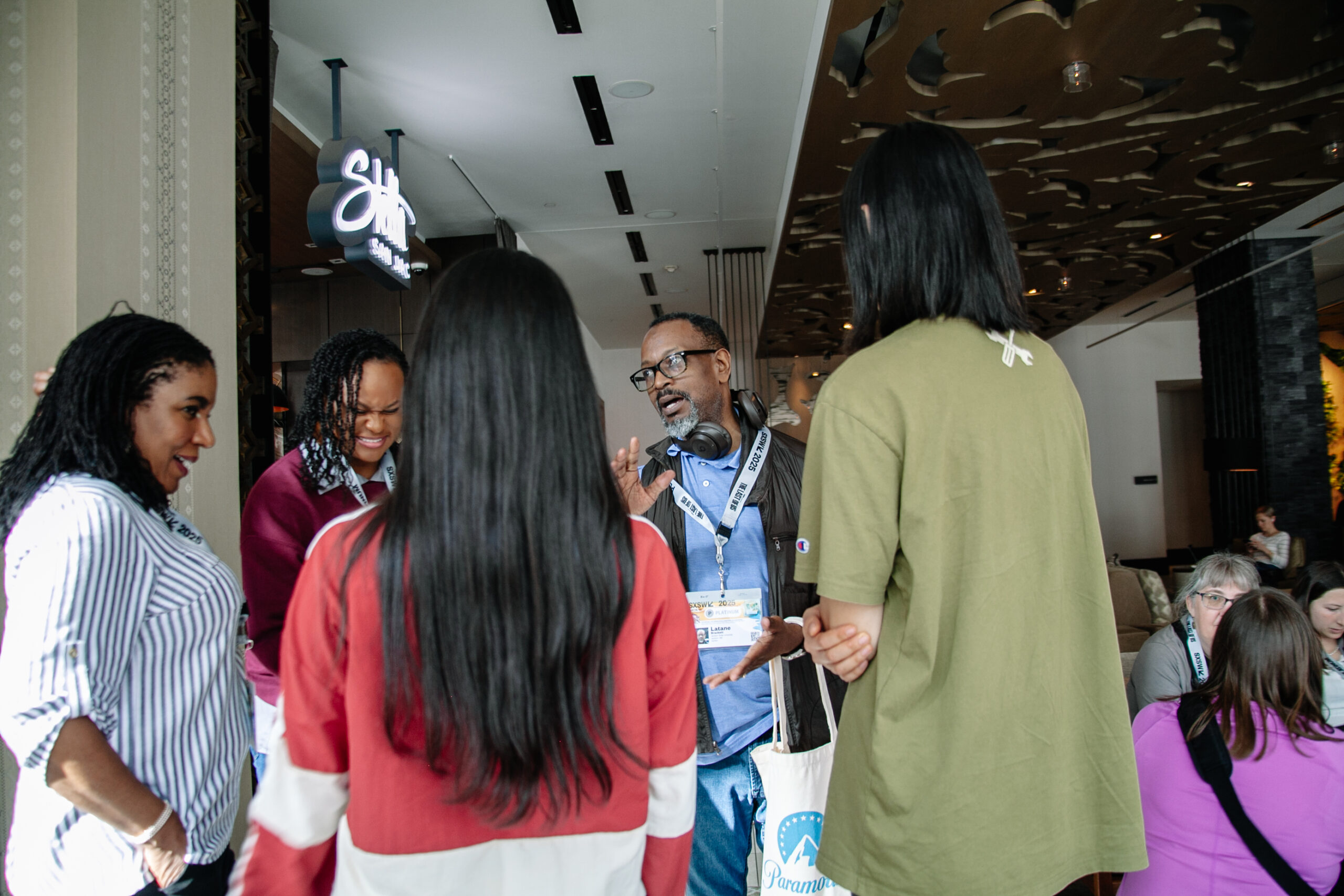 Group of people standing in a room.