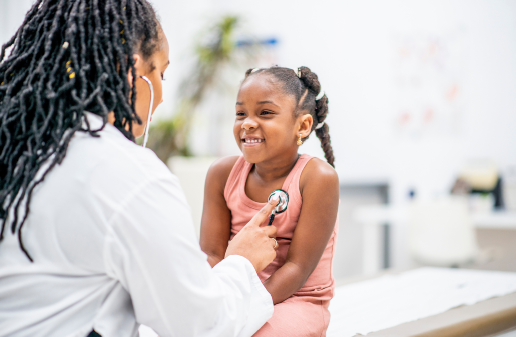 Woman physician listening to child's heart