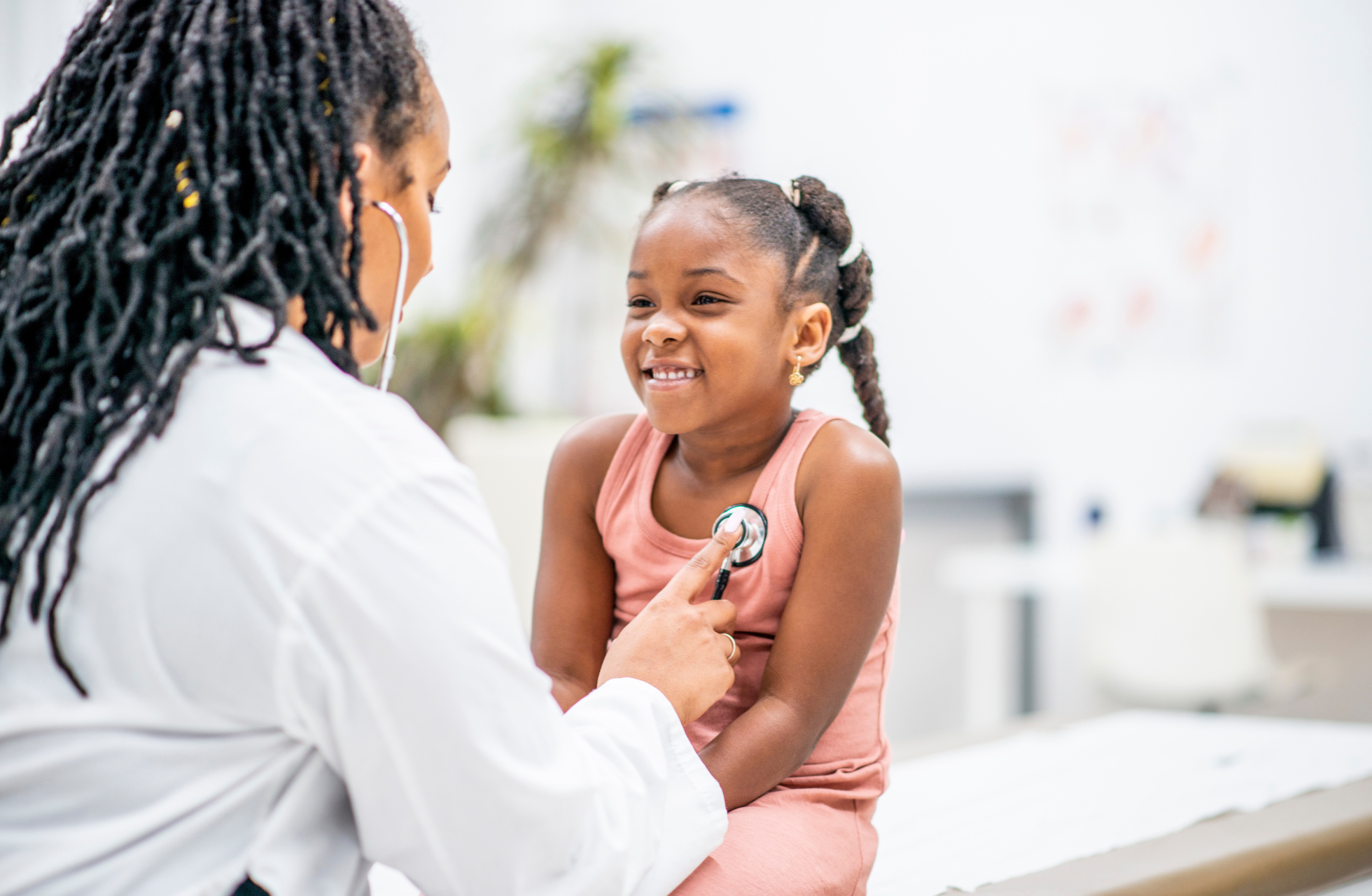 Woman physician listening to child's heart
